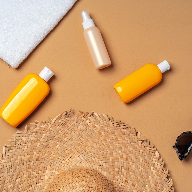Hat, sun tanning lotion, and sunglasses | All in Custom Spray Tanning